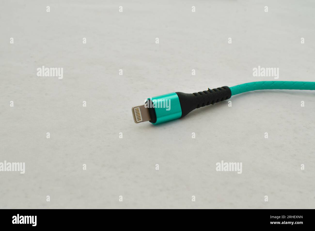 Apple USB cable connection detail highlighted on a light surface, perfect for modern technology concepts. Cable that provides speed and data transfer. Stock Photo