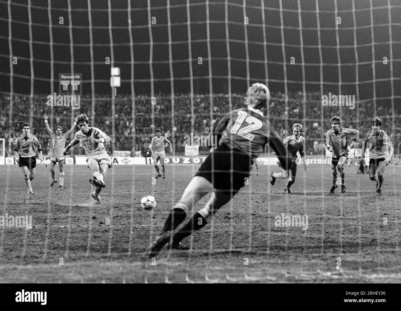 Krefeld, Deutschland, Europapokal der Pokalsieger Bayer Uerdingen (GER) vs. Dynamo Dresden (DDR)  7-3 am 19. 03. 1986  in der Grotenburg - Kampfbahn  in Krefeld. Wolfgang FUNKEL (Bayer Uerdingen ) 3.v.li.- verwandelt einen Handelfmeter in der 79. Spielminute zur 6-3 FŸhrung der Uerdinger, der das Erreichen des Halbfinale bedeutete. Ersatztorwart Jens RAMME ( Dynamo Dresden ) re.-  war machtlos. Foto: Norbert Schmidt, Duesseldorf Stock Photo