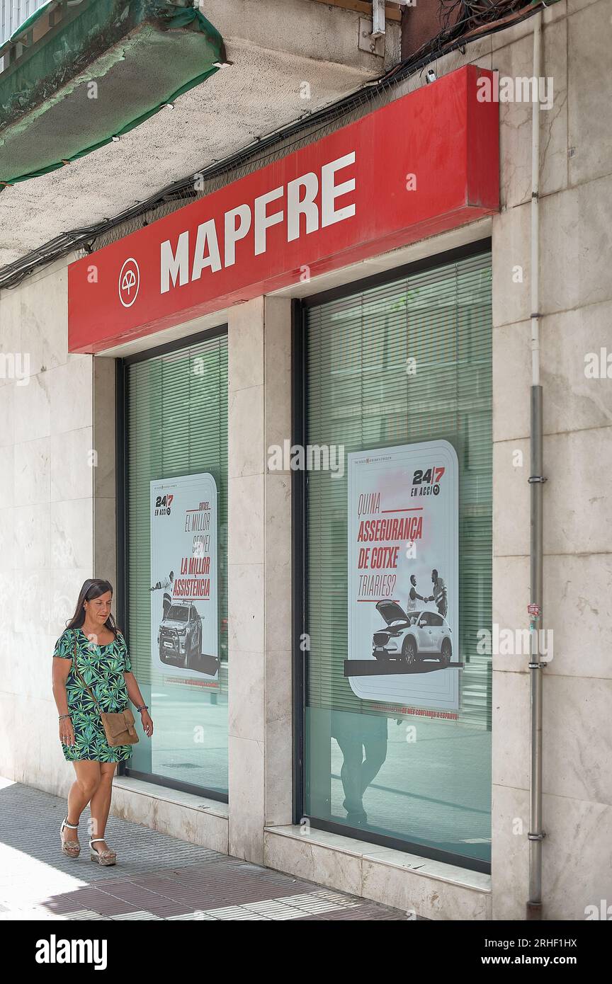 BARCELONA SPAIN - August 16, 2023: Woman passing in front of Mapfre. Stock Photo
