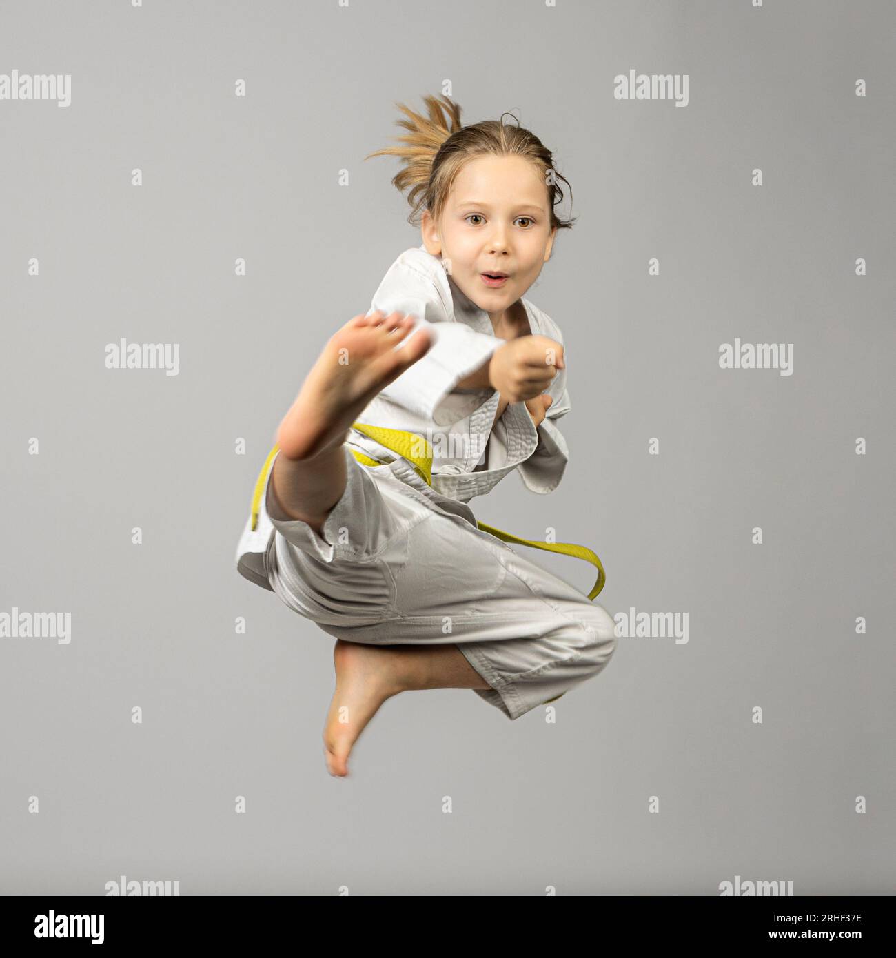 girl performs martial arts flying kick, studio shot Stock Photo Alamy