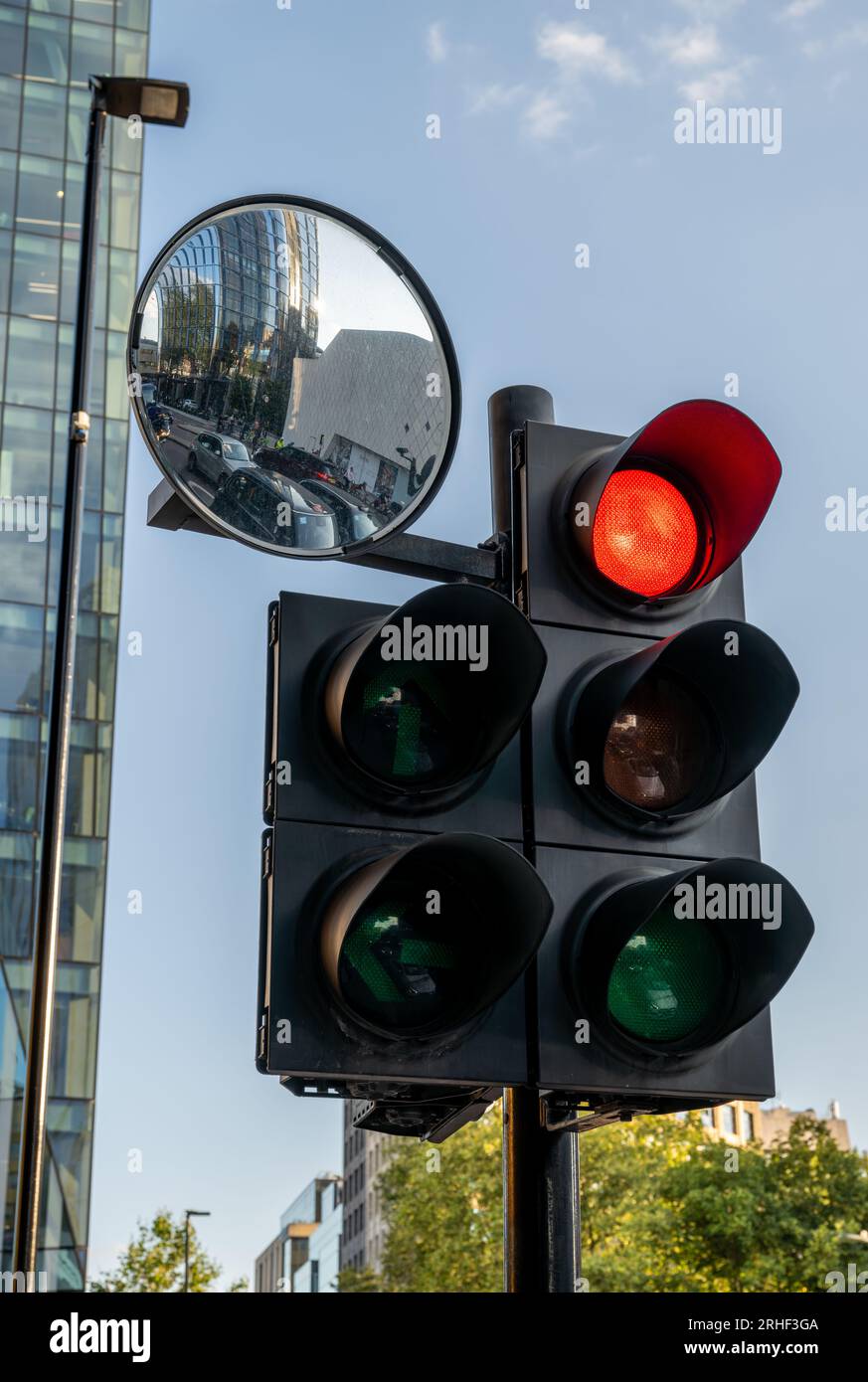 London, UK: Red traffic light in London. Stop light with mirror reflecting the waiting traffic. Stock Photo