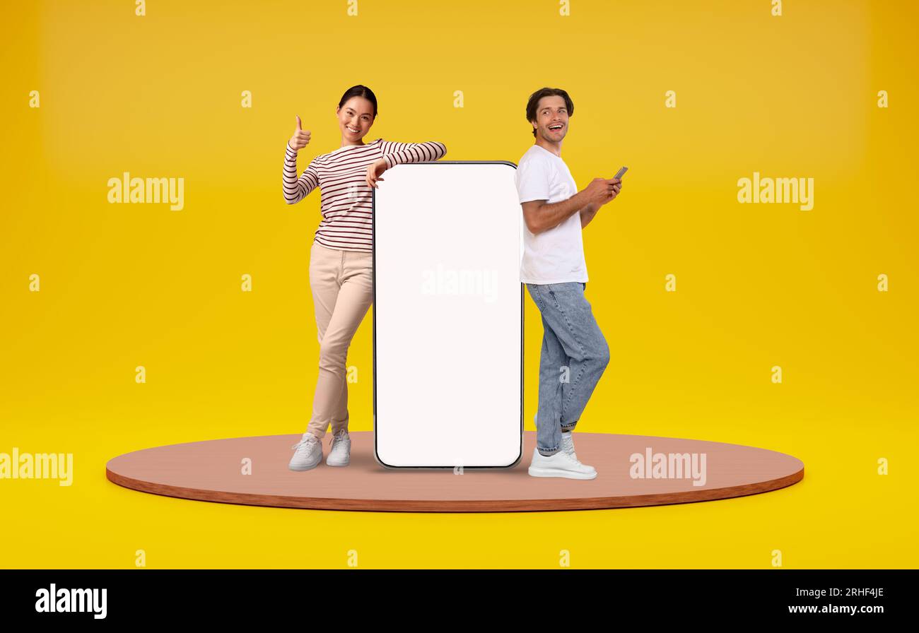 Man And Woman Leaning At Big Smartphone With Blank White Screen Stock Photo