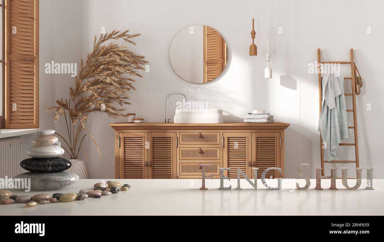 White table shelf with pebble balance and 3d letters making the word feng shui over scandinavian bathroom with wooden washbasin with mirror and decors Stock Photo