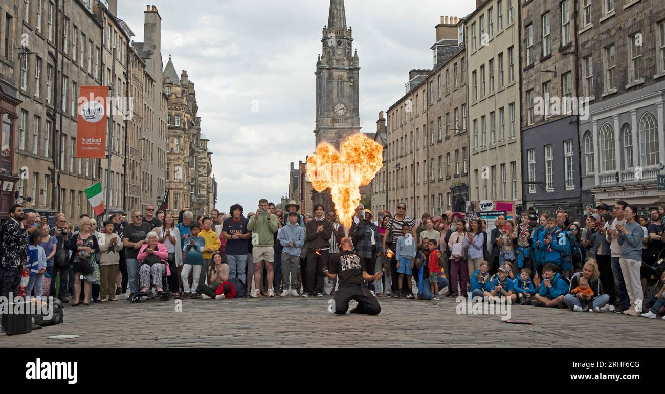 City centre, Edinburgh, Scotland, UK. 16 August 2023.  Cloudy conditions in the city centre for those visiting the Edinburgh Festival Fringe, small audiences for some street performers on the High Street. Pictured: Chinnen from Japan blows a fireball to conclude his show on the High Street. Credit: Archwhite/alamy live news Stock Photo