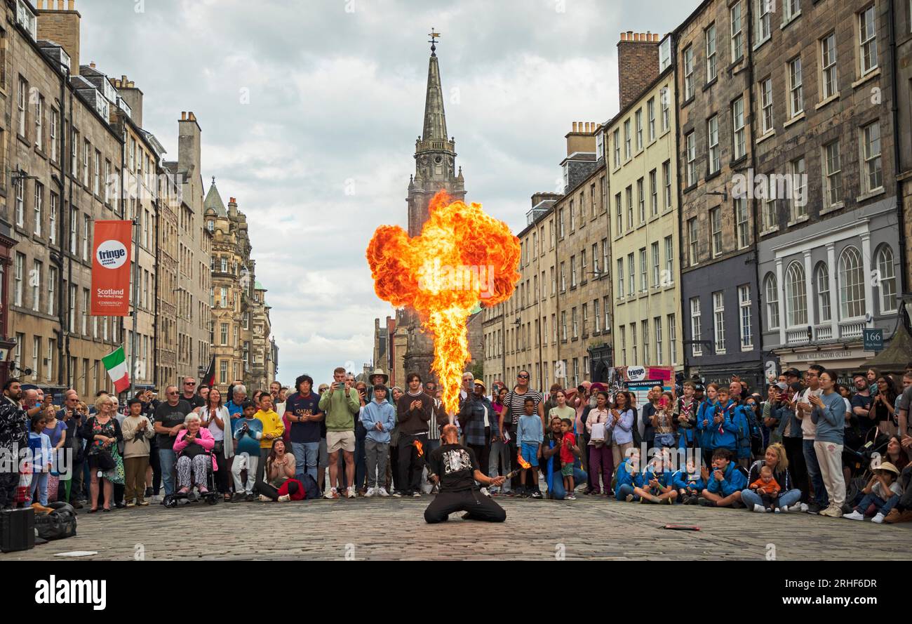 City centre, Edinburgh, Scotland, UK. 16 August 2023.  Cloudy conditions in the city centre for those visiting the Edinburgh Festival Fringe, small audiences for some street performers on the High Street. Pictured: Chinnen from Japan blows a fireball to conclude his show on the High Street. Credit: Archwhite/alamy live news Stock Photo