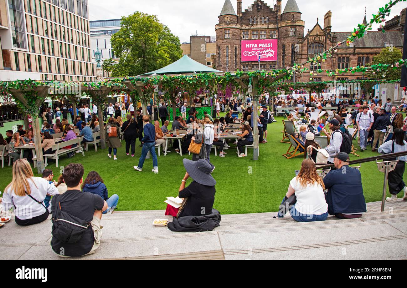 City centre, Edinburgh, Scotland, UK. 16 August 2023.  Cloudy conditions in the city centre for those visiting the Edinburgh Festival Fringe. Pictured: People relax at Bristo Square. Credit: Archwhite/alamy live news Stock Photo