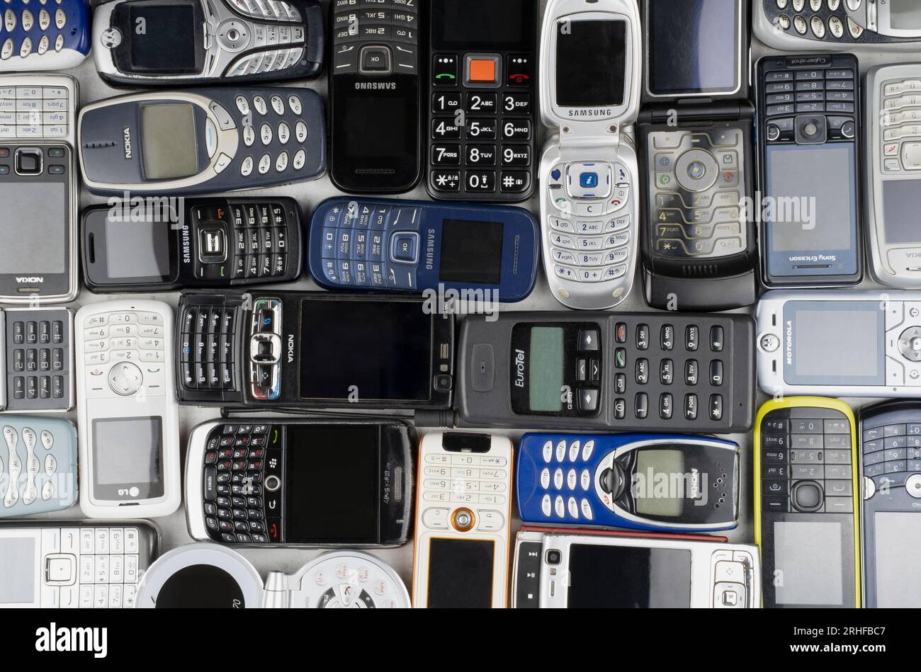 Prague, CZ -  12 December 2021:  A lot of old used mobile phones with keyboards, Various brands. Many types and generations of mobile smartphone gadge Stock Photo