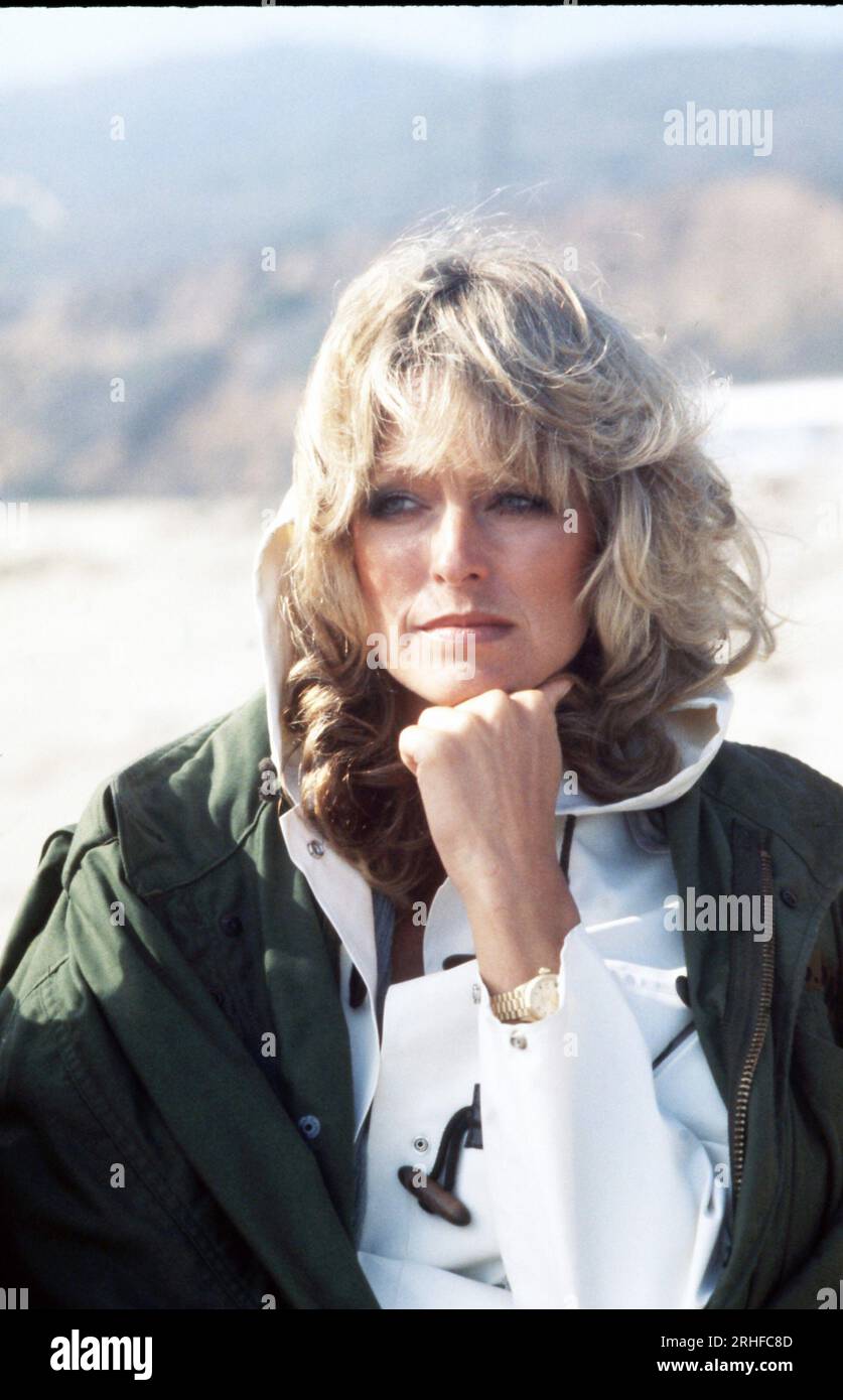 American actress Farrah Fawcett is strolling on the beach in a close-up,  hand to chin, during the filming of the Faberge Farrah Fawcett Shampoo  commercial, Los Angeles, CA, 1977. Photo: Oscar Abolafia/Everett