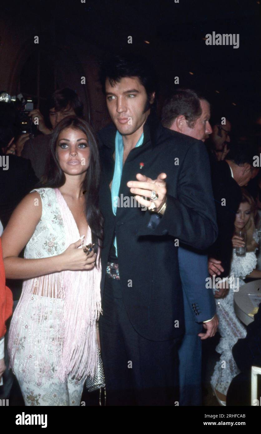 Elvis Presley wearing black jacket, with his wife Priscilla