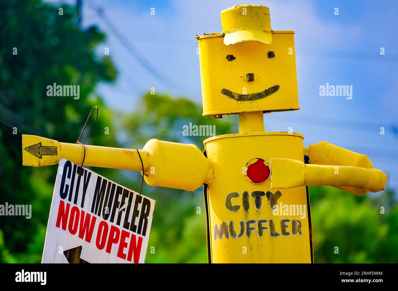 A muffler man points the way toward City Muffler auto repair shop, Aug