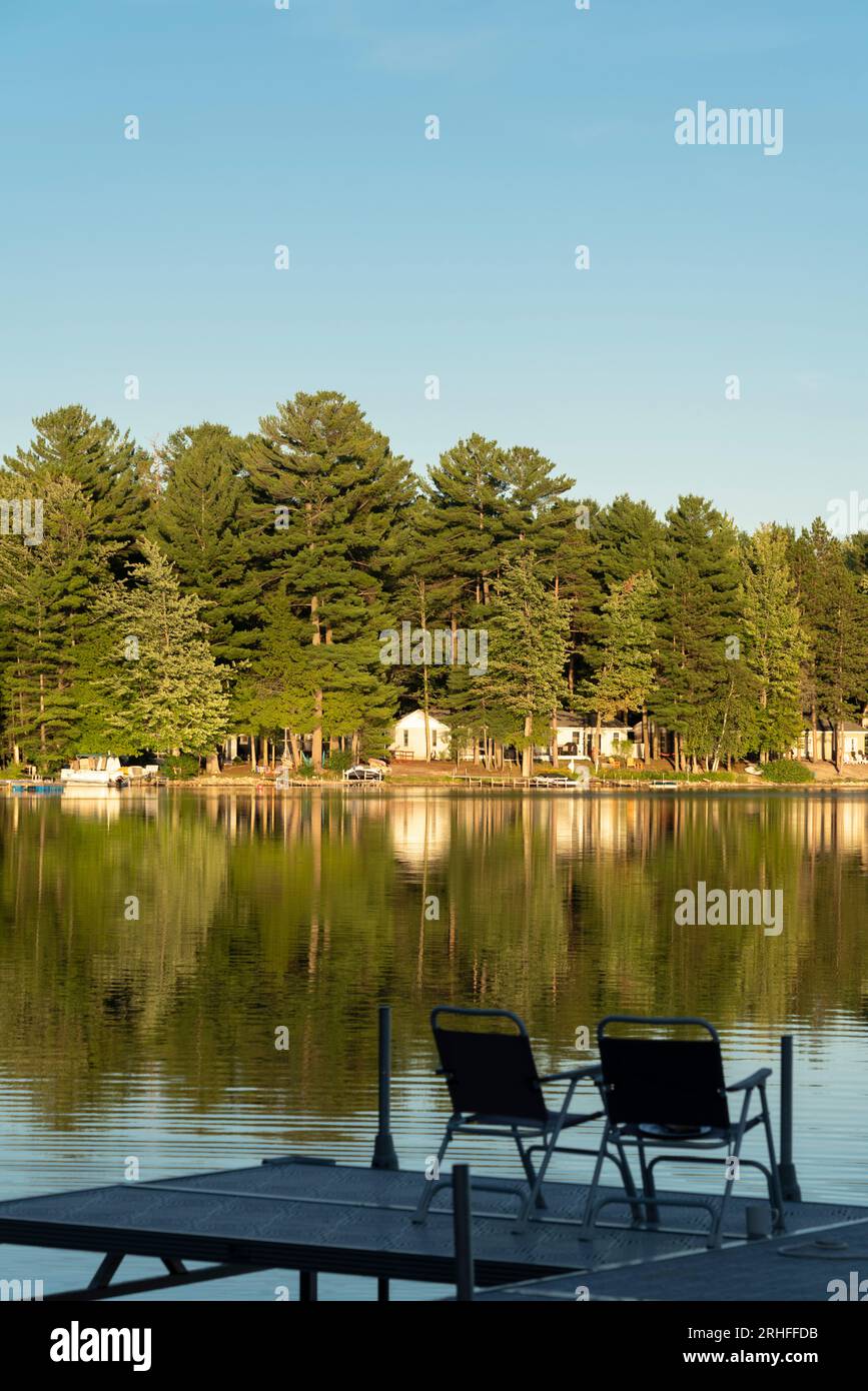 Chairs on Bass Lake near Interlochen, Michigan with summer cabins Stock