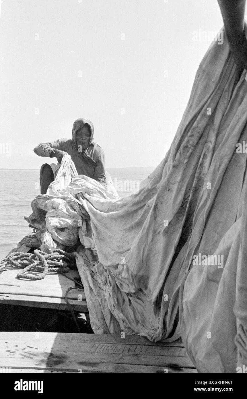 Ghanian fisherman at sea off Winneba, Ghana, about to set sail and return from a fishing trip, using the prevailing wind. Stock Photo