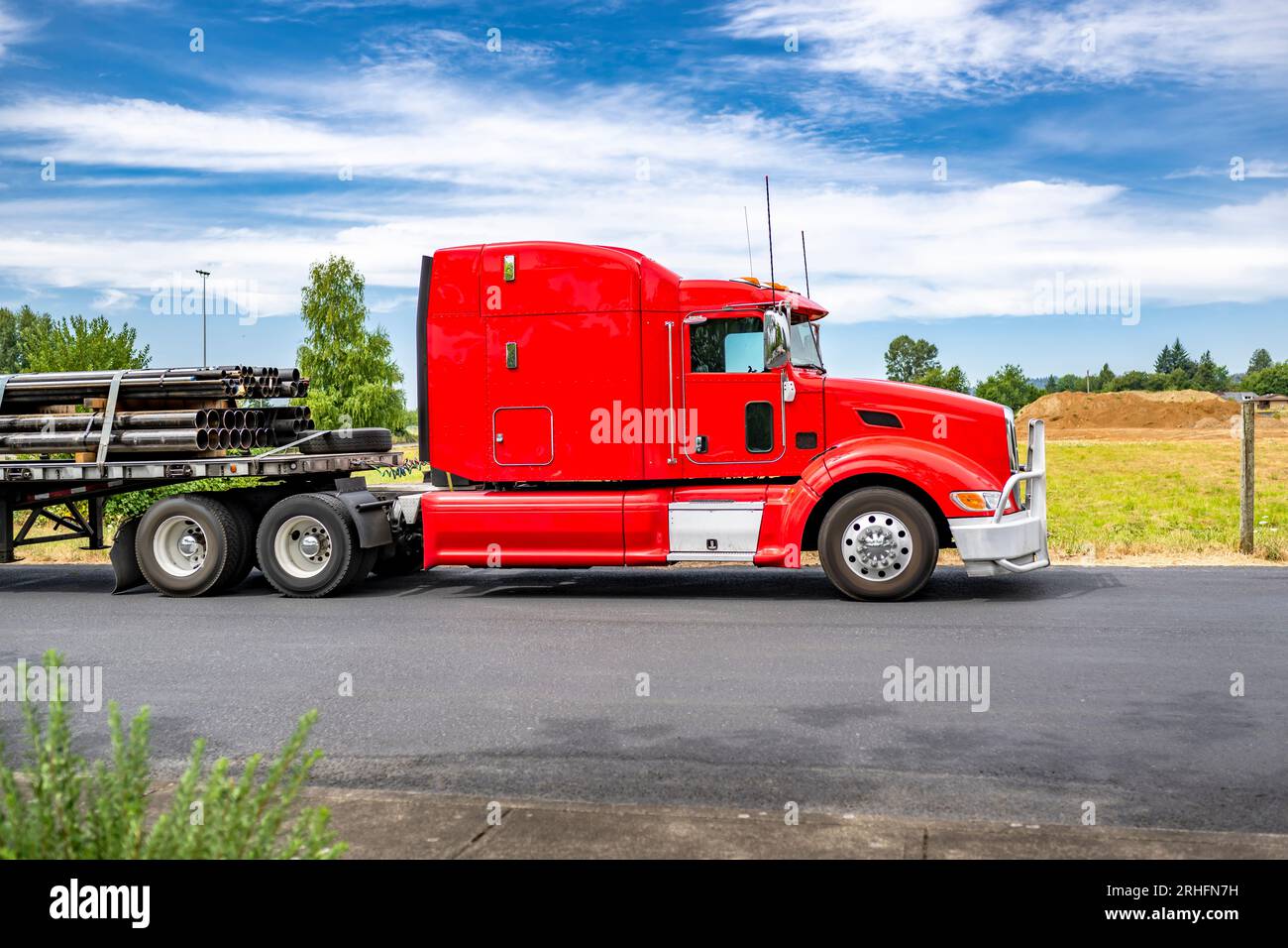 Long hauler big rig red semi truck tractor with grille guard and loaded