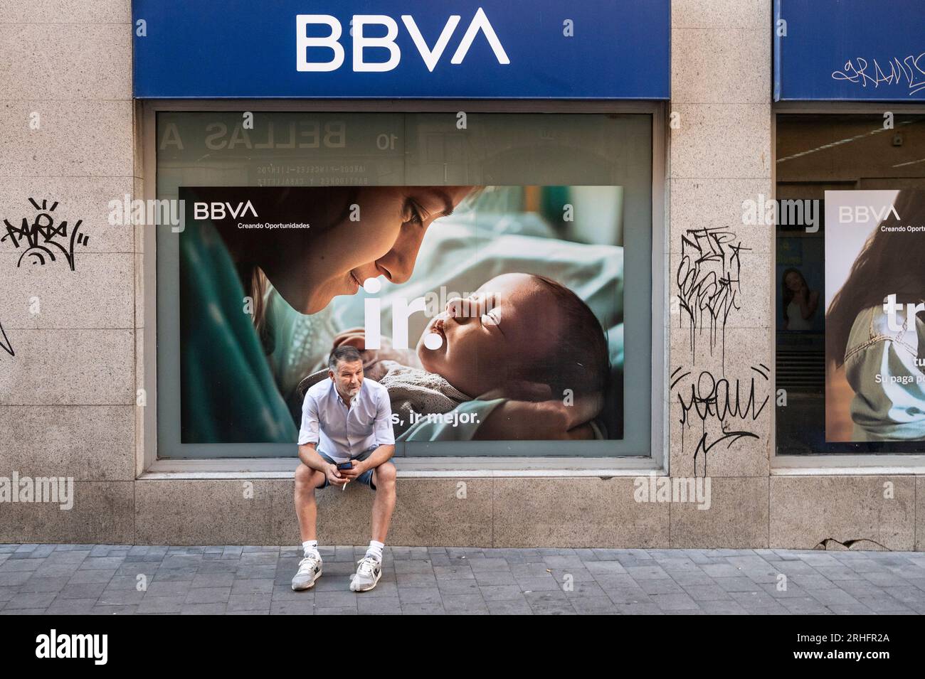 Madrid, Spain. 16th Aug, 2023. A man sits in front of the Spanish multinational Banco Bilbao Vizcaya Argentaria SA (BBVA) in Spain. (Photo by Xavi Lopez/SOPA Images/Sipa USA) Credit: Sipa USA/Alamy Live News Stock Photo
