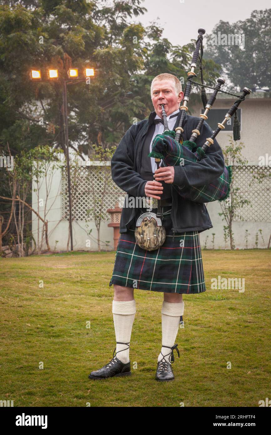 Scottish piper from Scotland in traditional outfit with tartan kilt playing bagpipe Stock Photo