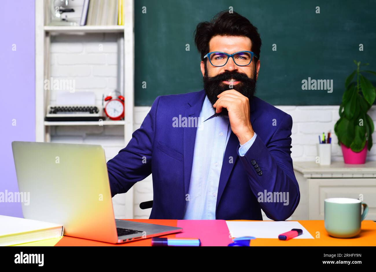 Smiling teacher at workplace. Profession, learning and tutoring. High school. Knowledge day. Bearded professor at school lesson in classroom. Teacher Stock Photo