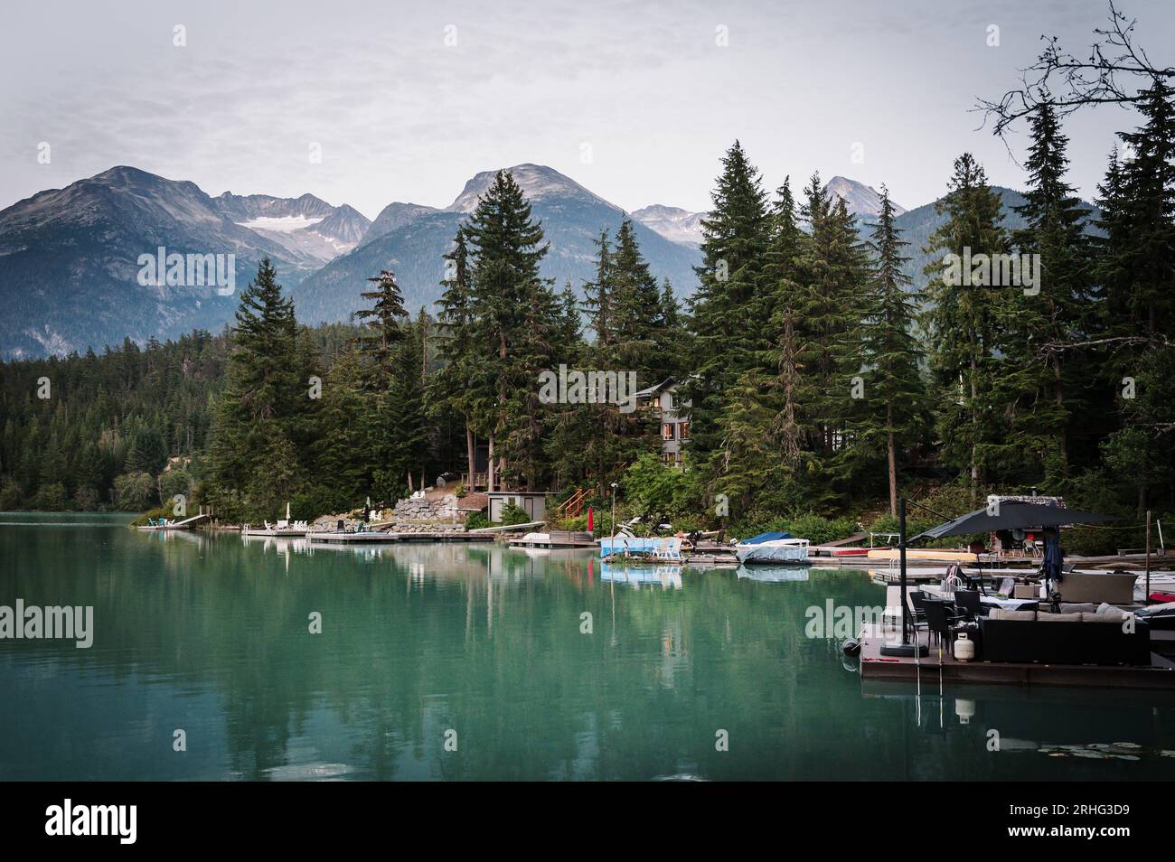 Green Lake waterfront houses with mountains in the background at sunset.  Whistler BC, Canada. Stock Photo