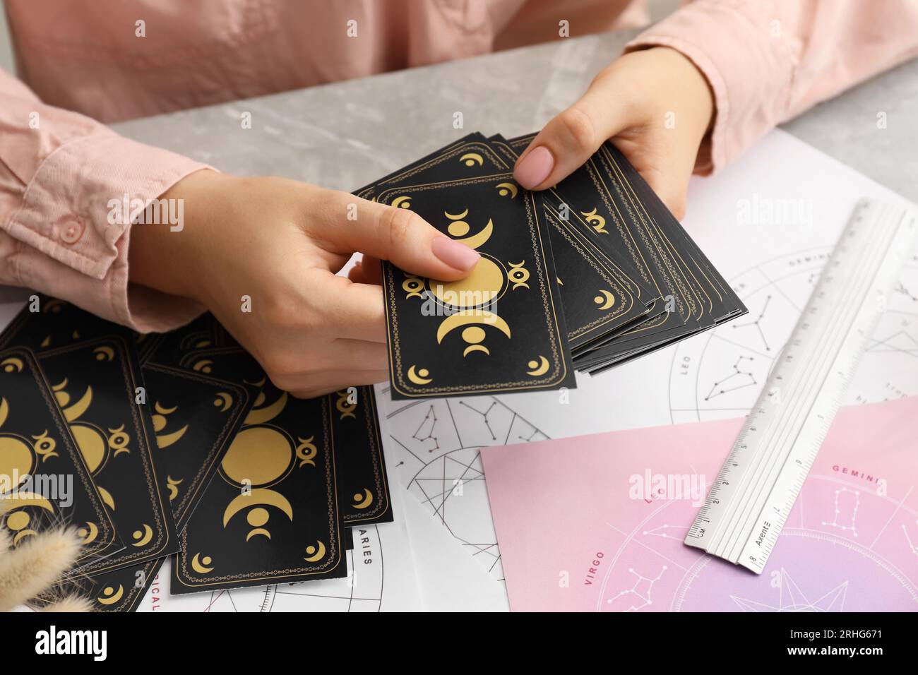 Woman using tarot cards at table, closeup. Astrological predictions Stock Photo