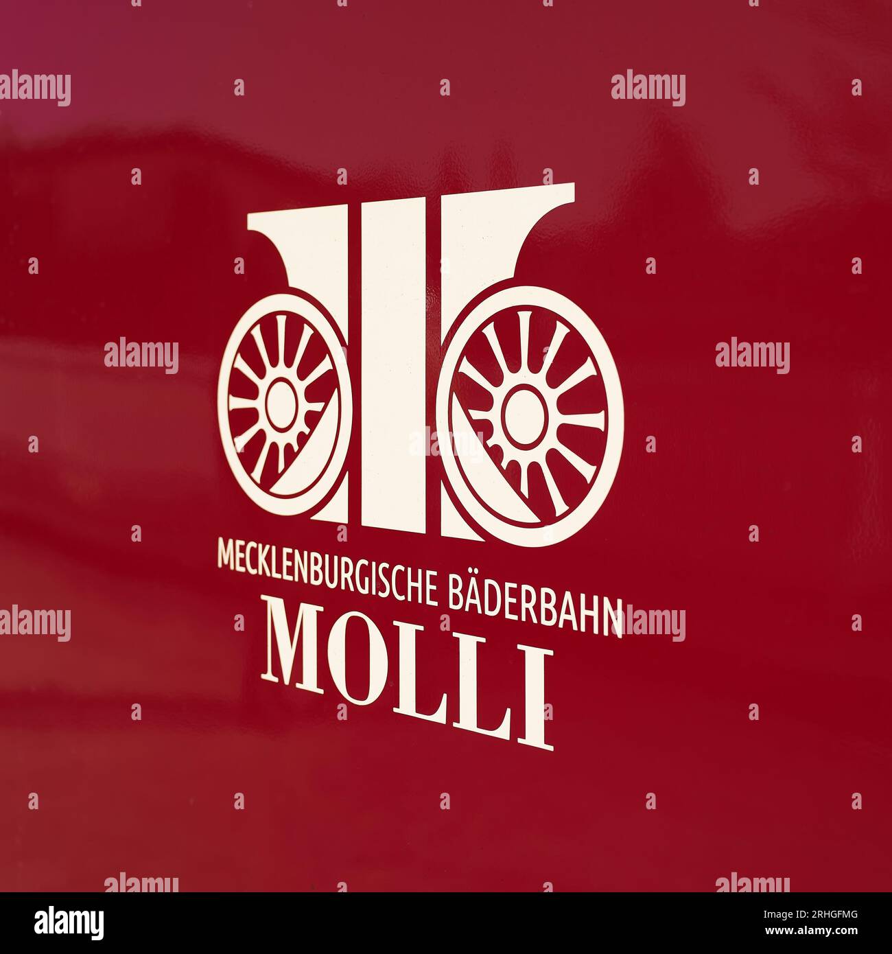 Symbol of Mecklenburgische Bäderbahn Molli GmbH on a red wagon of the narrow-gauge railroad in Heiligendamm station in Germany Stock Photo