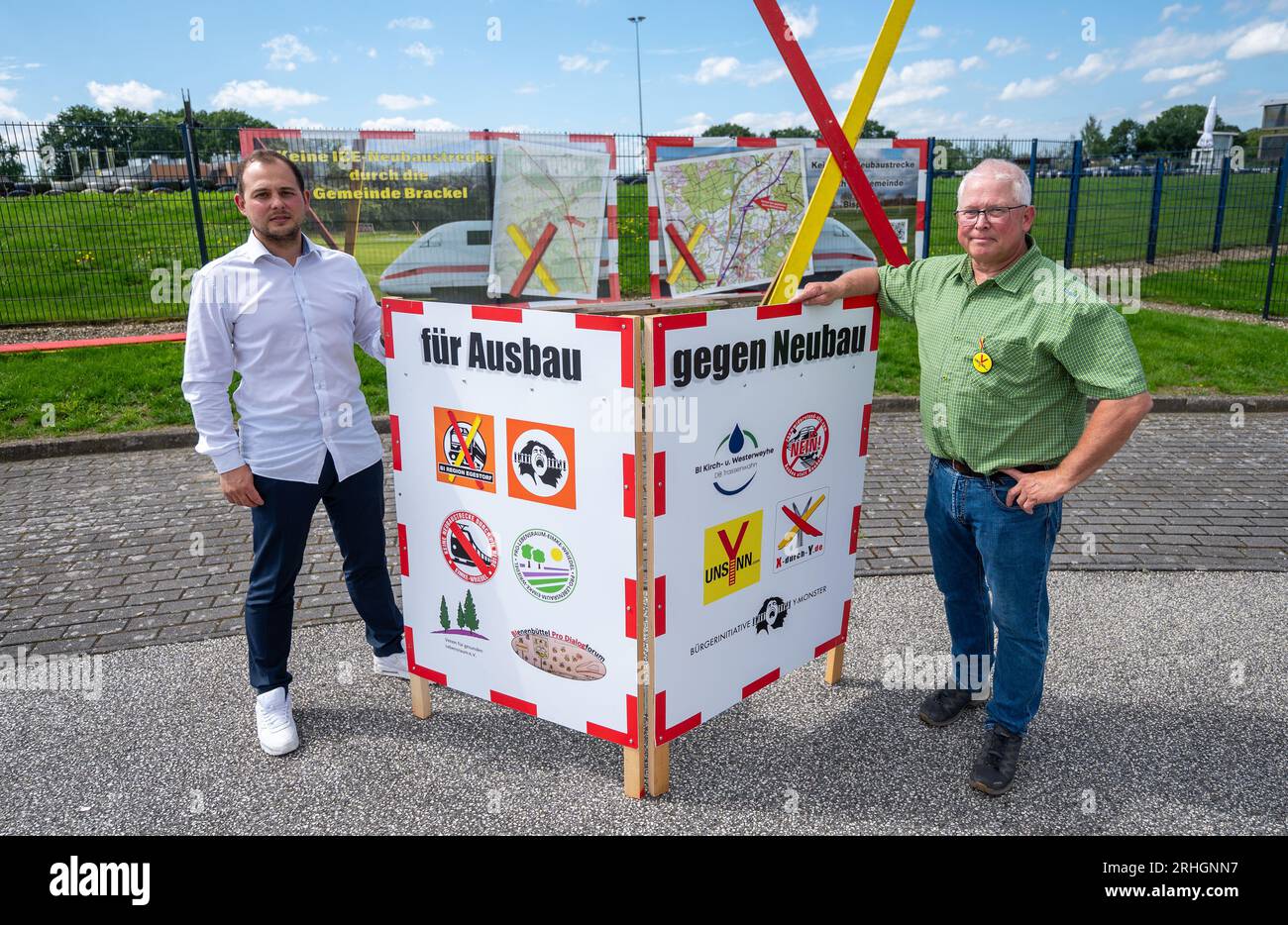 PRODUCTION - 14 August 2023, Lower Saxony, Bispingen: Malte Schmidt (l), Managing Director of the Ralf Schumacher Cart Center, and Stephan Müller (r), Citizens' Initiative (BI) Unsynn, stand in front of protest signs. The railroad is enticing residents with somewhat shorter travel times between Hamburg and Hanover and, in the permanent conflict, probably favors the new construction variant along the A7. Residents are fighting back and believe the company has a duty to first rehabilitate the existing line. (to dpa 'New construction or expansion of the Hanover-Hamburg rail line? Residents concer Stock Photo
