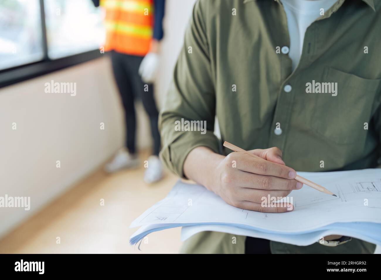 Engineer or architect holding a pencil working on the blueprint at the ...