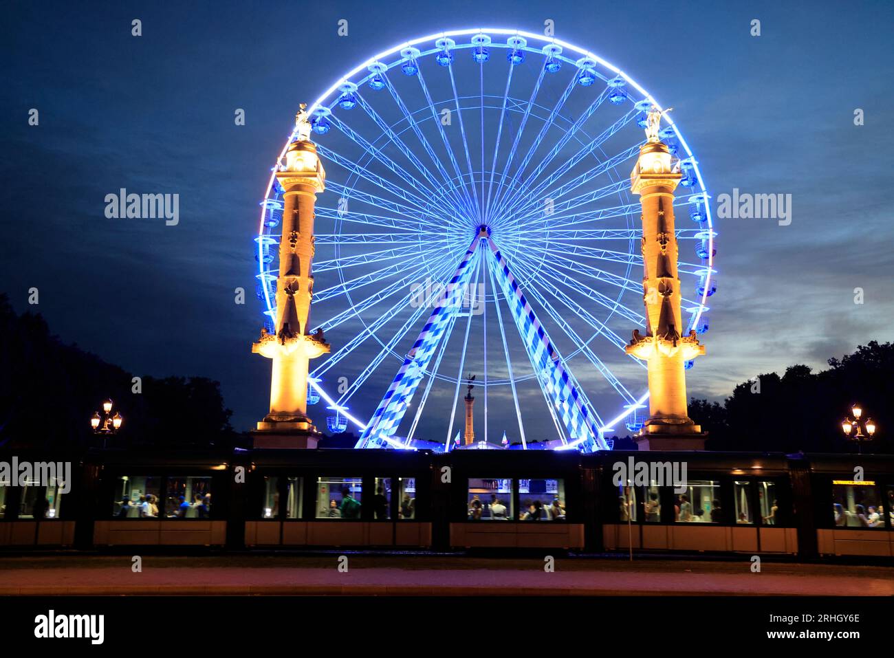 Les Colonnes Rostrales de Bordeaux de nuit sur la place des Quinconces face à la rivière Garonne avec une Grande Roue animation de l’été. Bordeaux, Gi Stock Photo