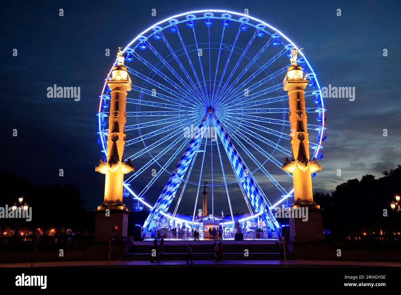 Les Colonnes Rostrales de Bordeaux de nuit sur la place des Quinconces face à la rivière Garonne avec une Grande Roue animation de l’été. Bordeaux, Gi Stock Photo