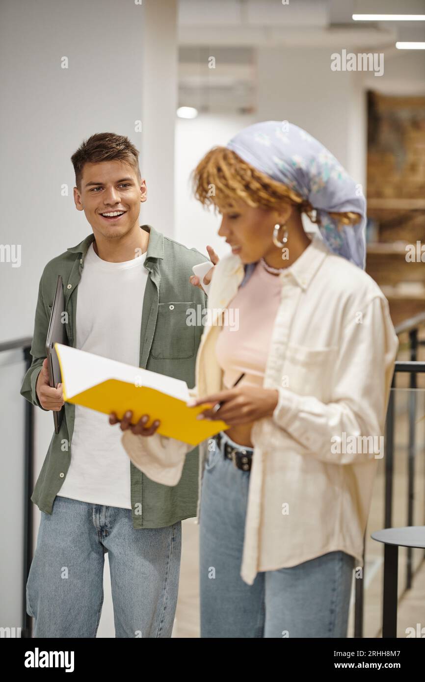 cheerful young man looking at african american colleague, black woman, startup culture, diverse Stock Photo