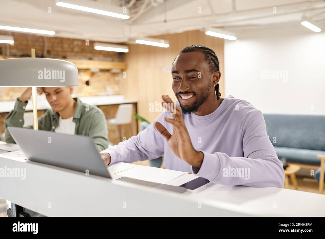 coworking, happy african american man having video call, using laptop, startup, hello, generation z Stock Photo