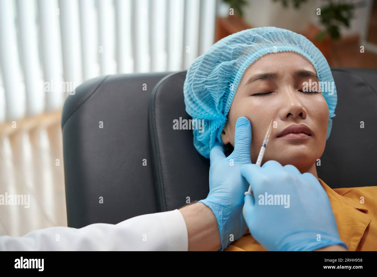 Woman getting painful collagen injections in nasolabial fold Stock Photo