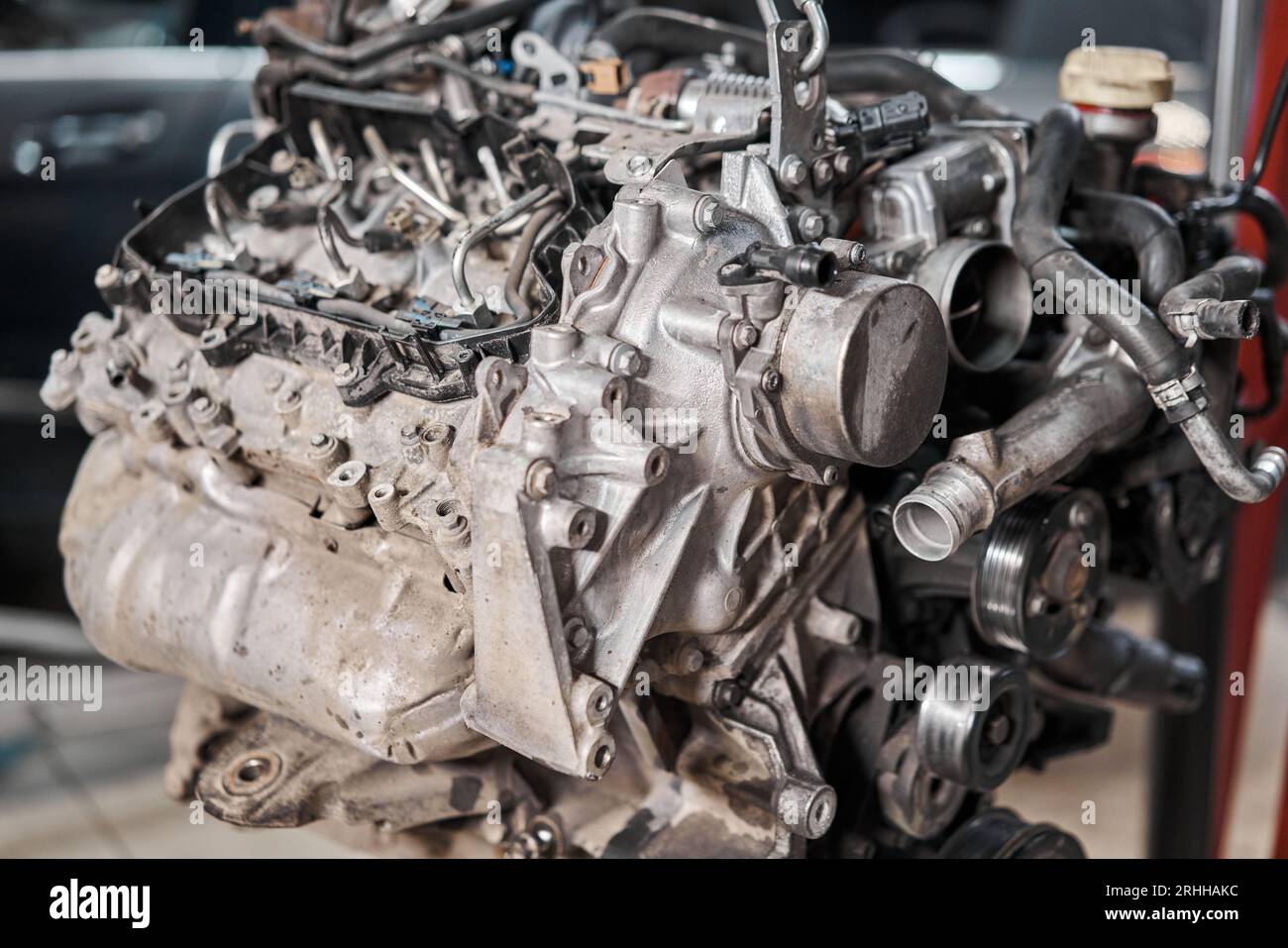 A car mechanic inspects the engine with a flashlight. Engine Block on a