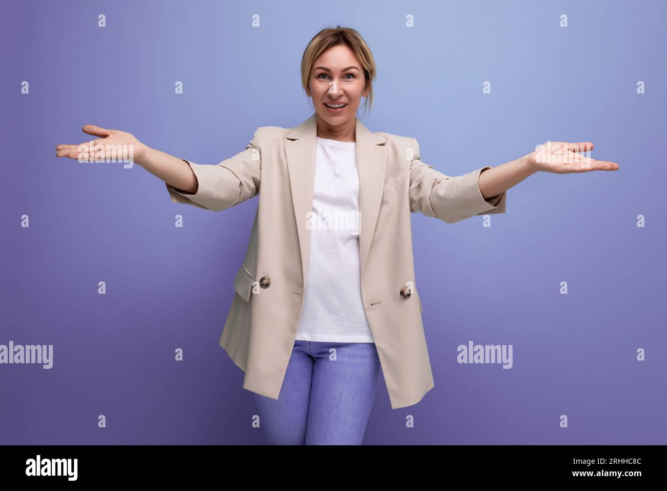 blond young woman in a jacket welcomes in open arms Stock Photo - Alamy