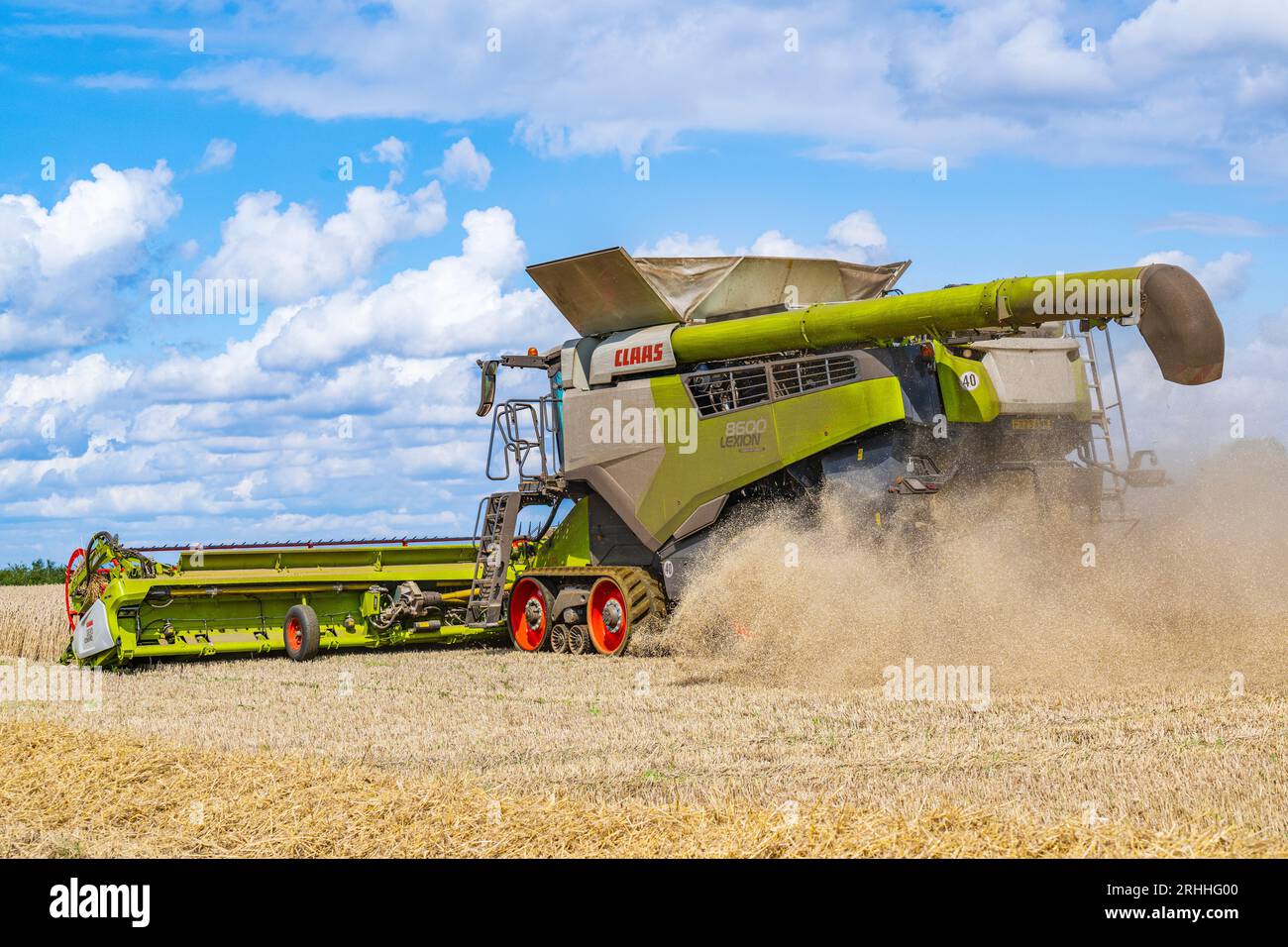 A Claas combine harvester working to harvest the corn on a summer’s day in the UK Stock Photo
