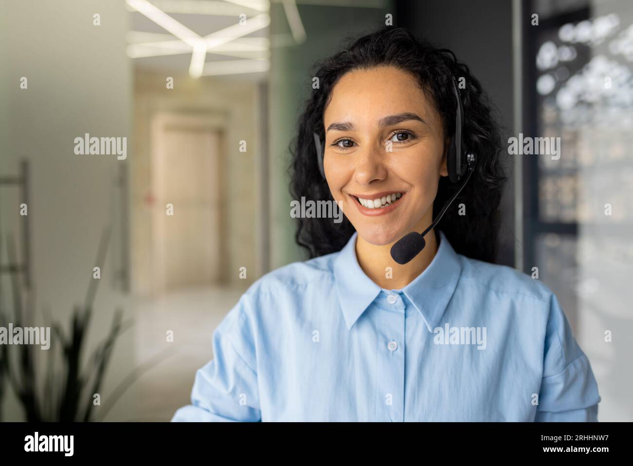 Close-up portrait of young Hispanic business woman smiling at workplace ...