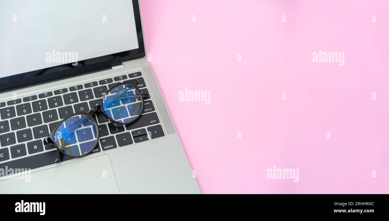 Glasses are placed on a laptop Stock Photo