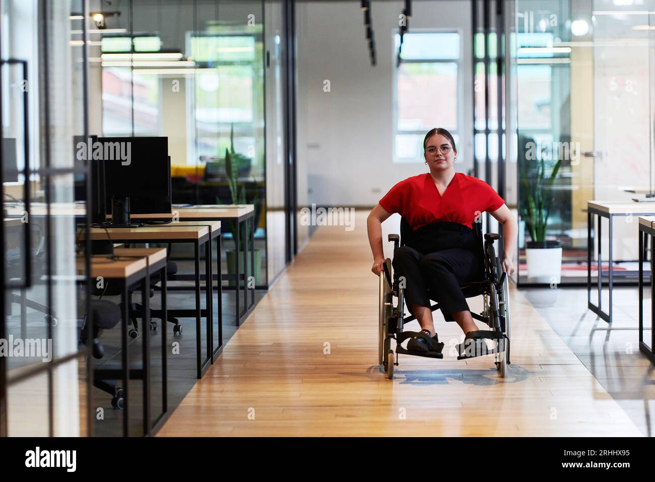A modern young businesswoman in a wheelchair is surrounded by an ...