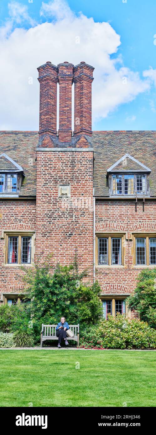 A member of staff sits below a three chimney pots at Library Court, Pembroke College, founded in the 14th century, University of Cambridge, England. Stock Photo