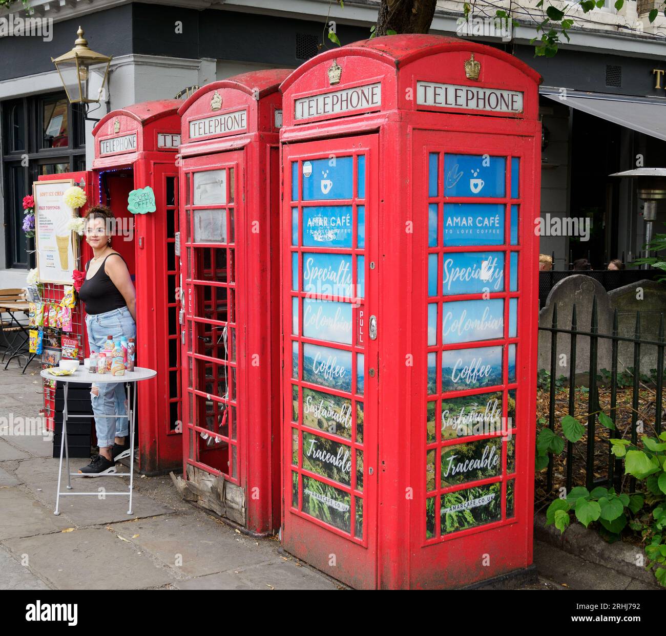 Entrepreneur with a pop-up cafe and ice cream shop in a K7 telephone kiosk in Greenwich London UK Stock Photo