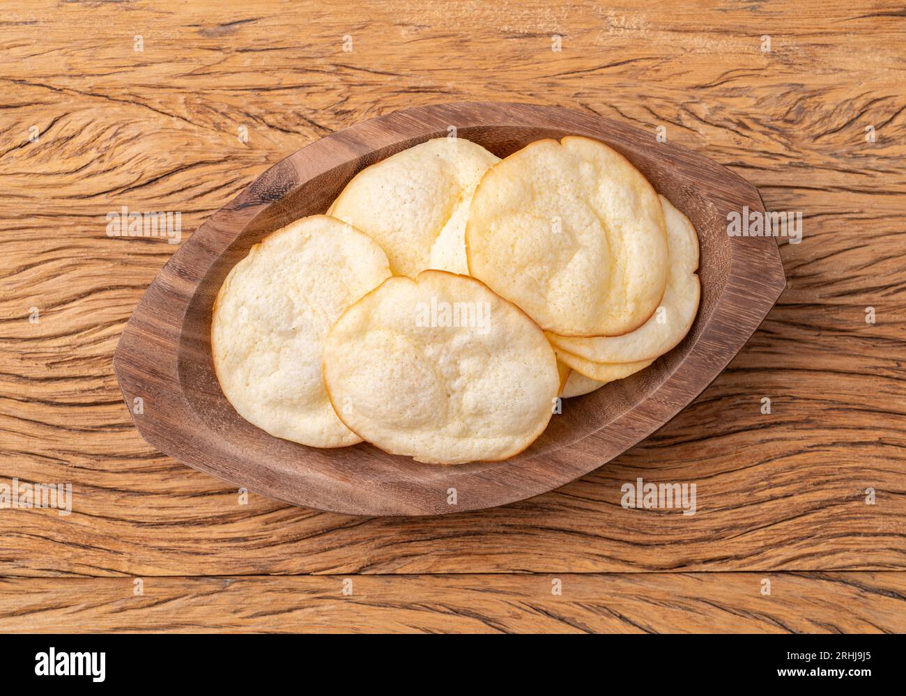 Smoked provolone cheese chips in a bowl over wooden table. Stock Photo