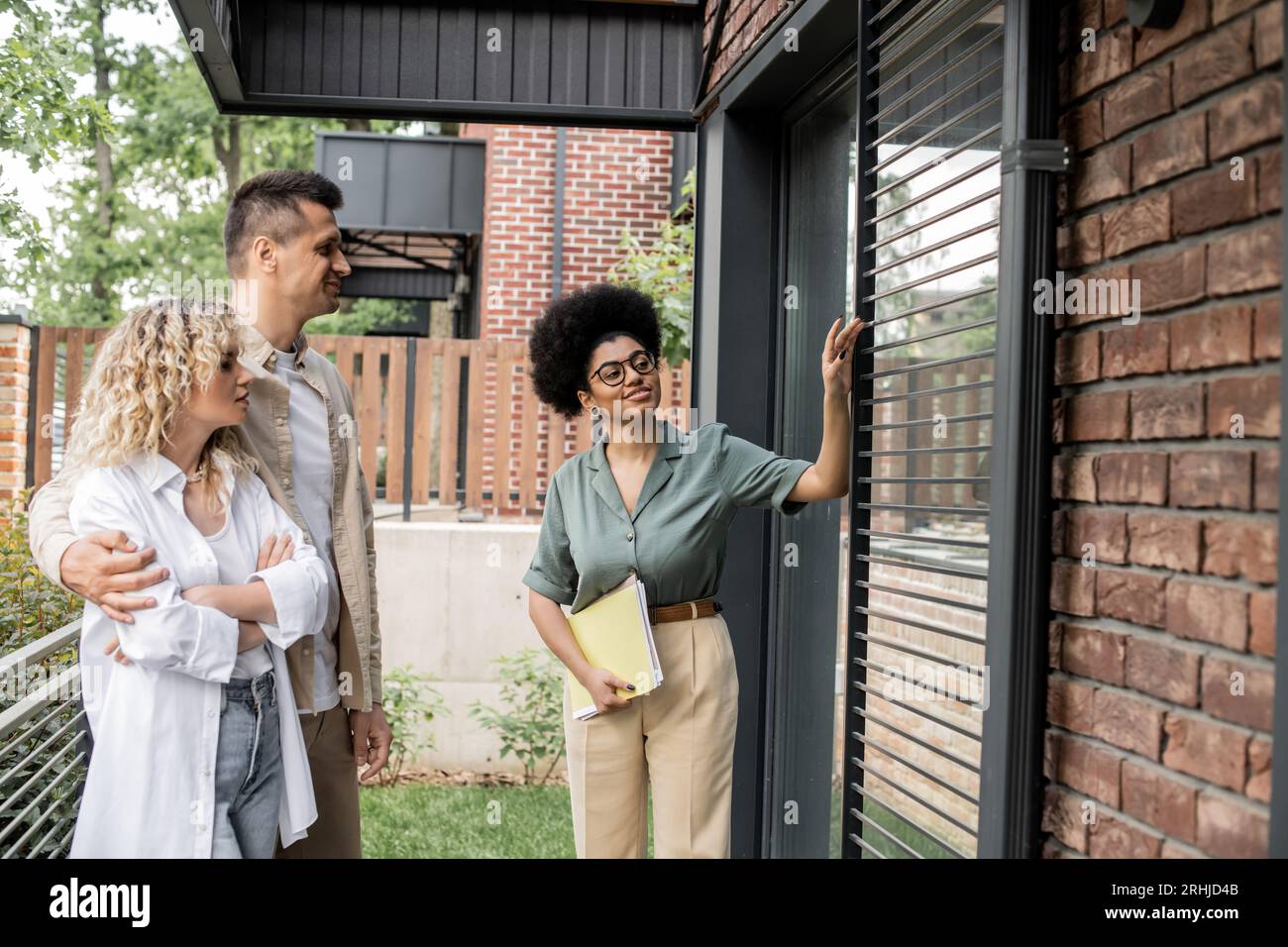 pleased african american real estate broker with documents showing new ...