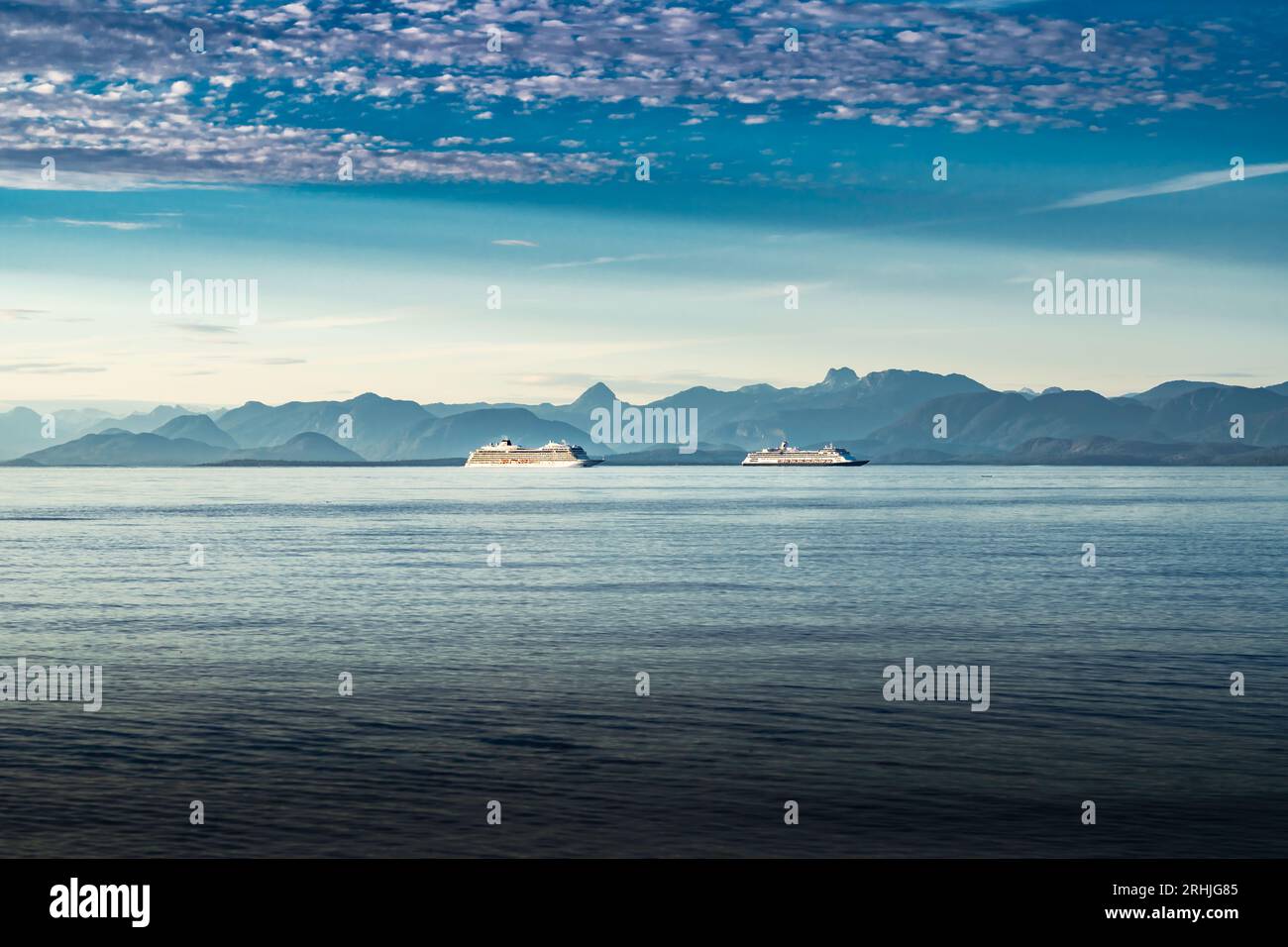 Pair of cruise ships navigate through the Gulf Islands of British Columbia overlooking the Sunshine Coast near Campbell River under a dramatic sunset Stock Photo