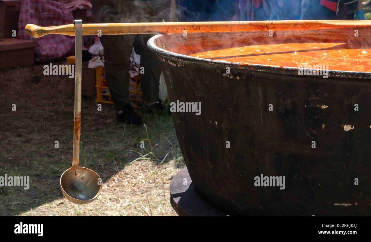 Tomato soup with pasta is a dish of Polish cuisine. Hot Zupa pomidorowa in a large cauldron at the field kitchen at a food fair. A popular soup made Stock Photo
