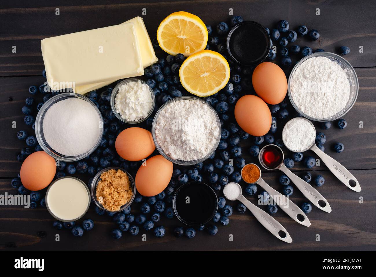 Blueberry Cobbler Cake Ingredients on a Dark Wood Table: Fresh blueberries, lemons, and other raw ingredients on a rustic wooden background Stock Photo