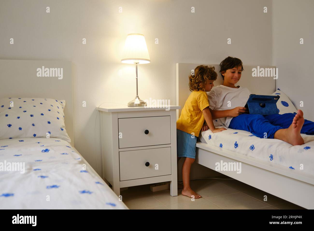Brothers using tablet in bedroom Stock Photo