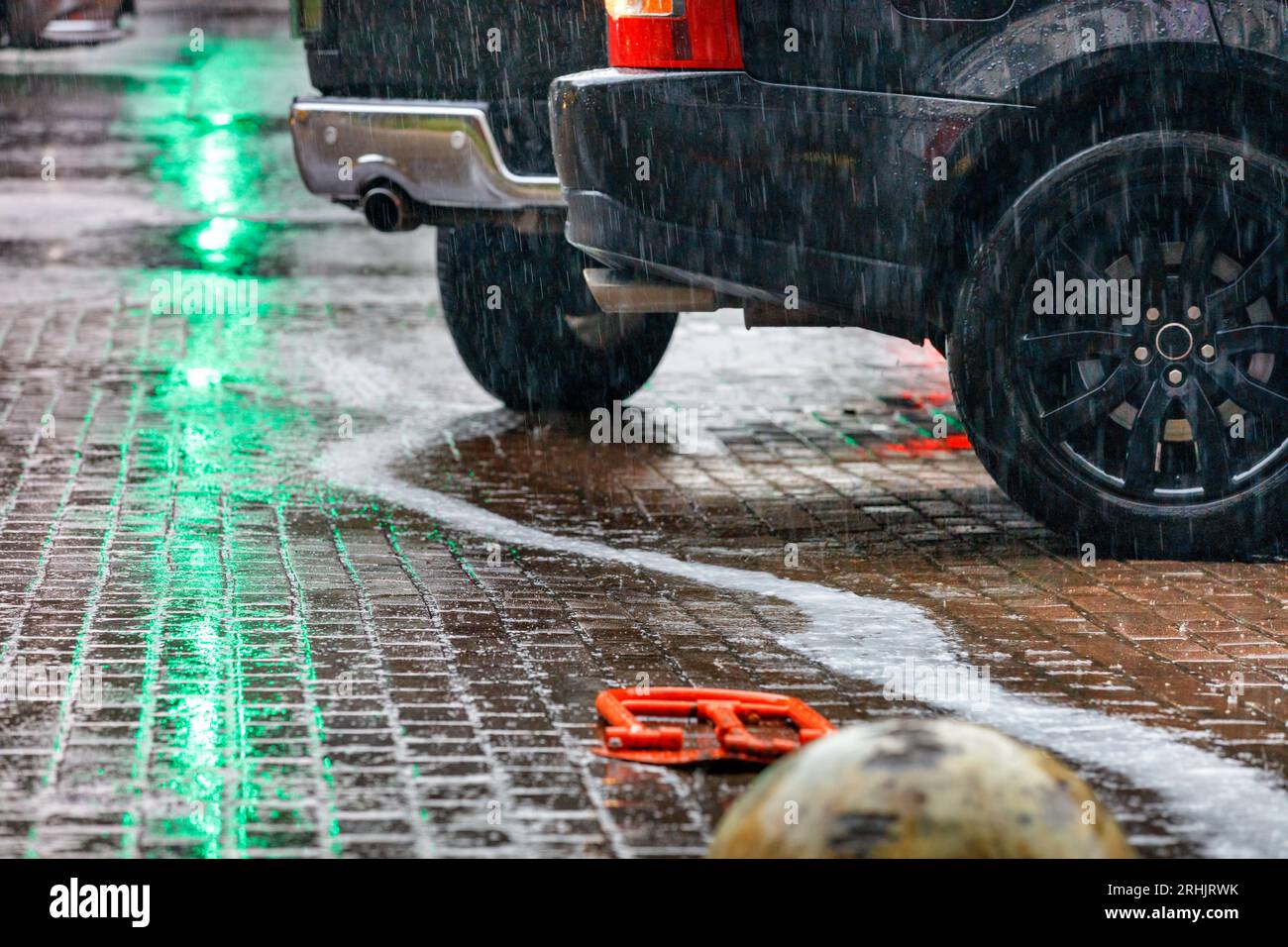 Heavy rain in the parking lot and the reflection of the green light of