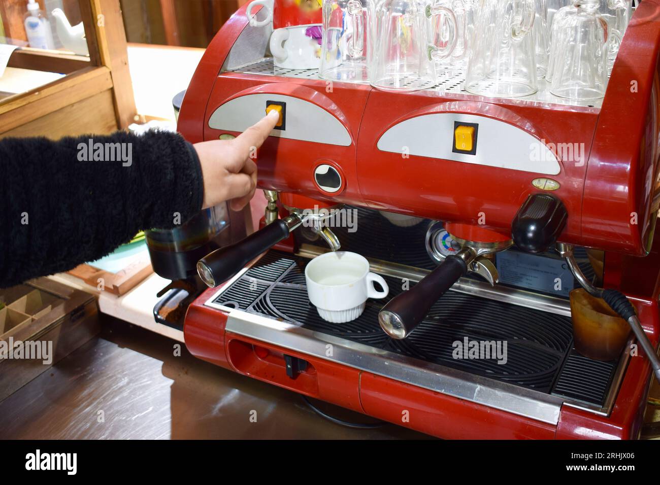 Pressing the switch on the coffee maker to dispense Stock Photo - Alamy