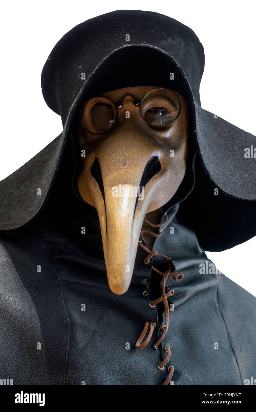 Black wide-brimmed hat, overcoat and beaked mask for plague doctor to treat victims of bubonic plague during epidemic on white background Stock Photo