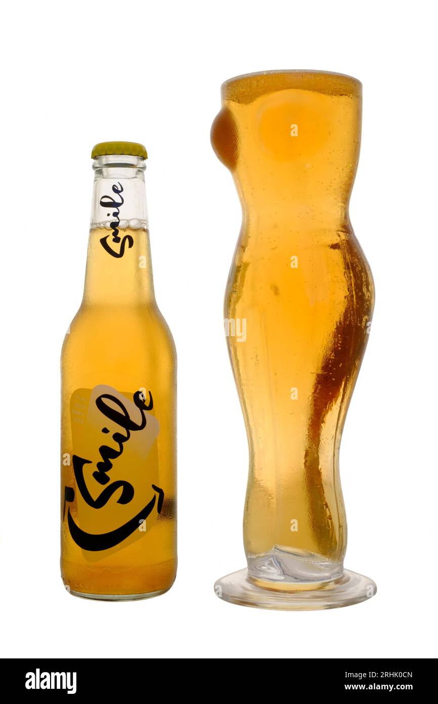 glass in shape of naked nude woman female full of beer alongside bottle of smile lager on white background Stock Photo