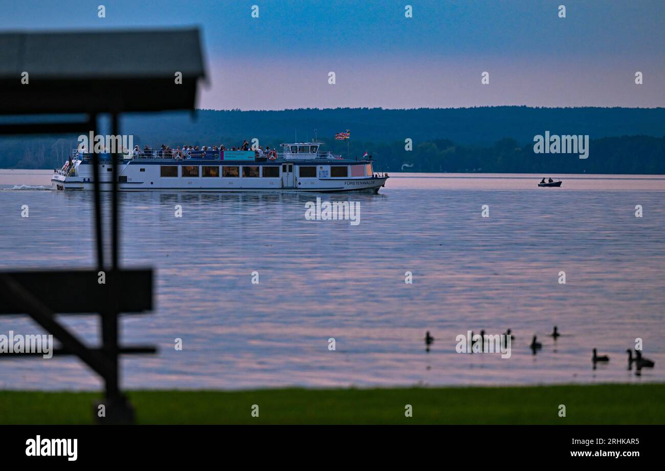 Diensdorf Radlow, Germany. 17th Aug, 2023. A passenger ship is underway on Lake Scharmützel in the evening. The body of water in the Storkower Land region, also called the Märkisches Meer by Fontane, is the largest lake in Brandenburg with a water surface area of about 1,500 hectares. Credit: Patrick Pleul/dpa/Alamy Live News Stock Photo