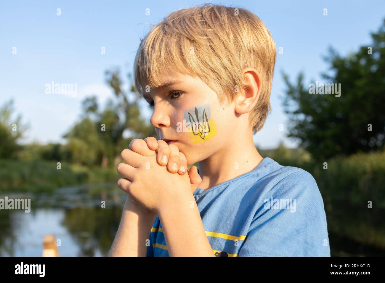 unhappy sad boy with a painted trident on his cheek Stock Photo
